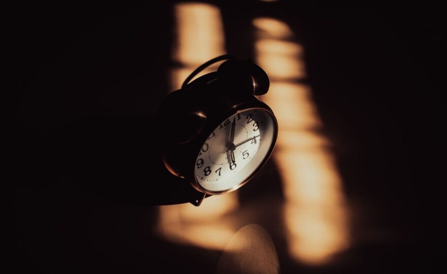 Schwarzer Wecker im warmen Licht – Symbol für Schlafrhythmus und innere Uhr