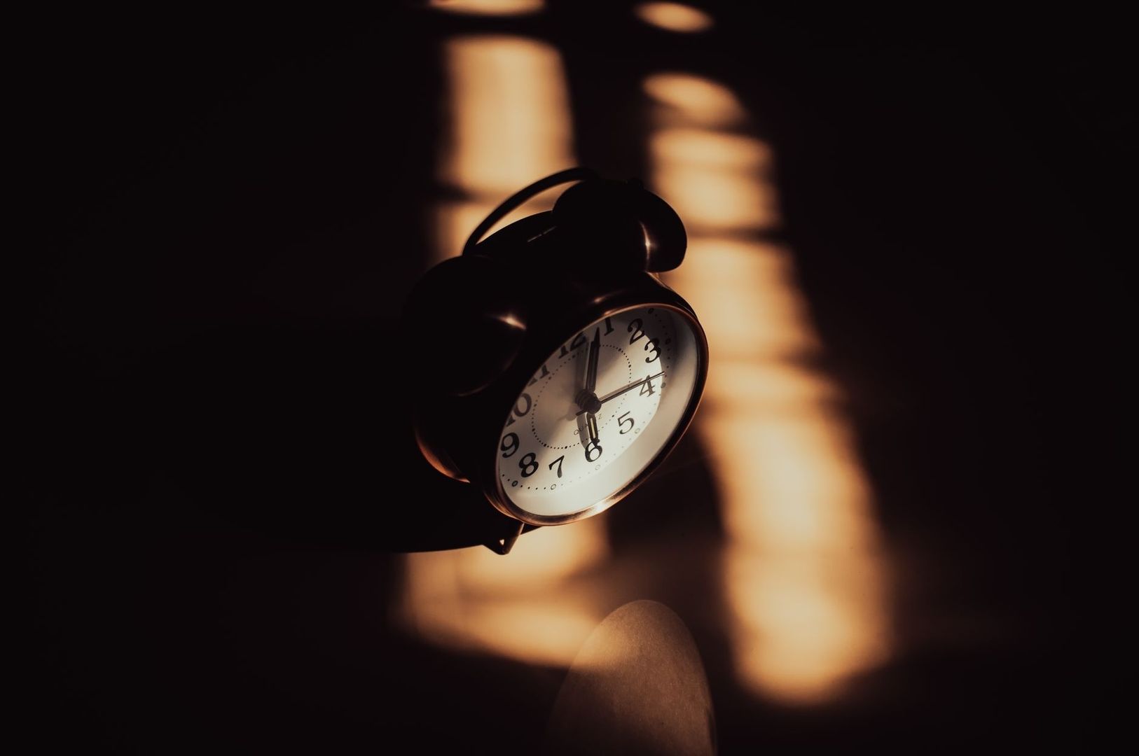 Schwarzer Wecker im warmen Licht – Symbol für Schlafrhythmus und innere Uhr