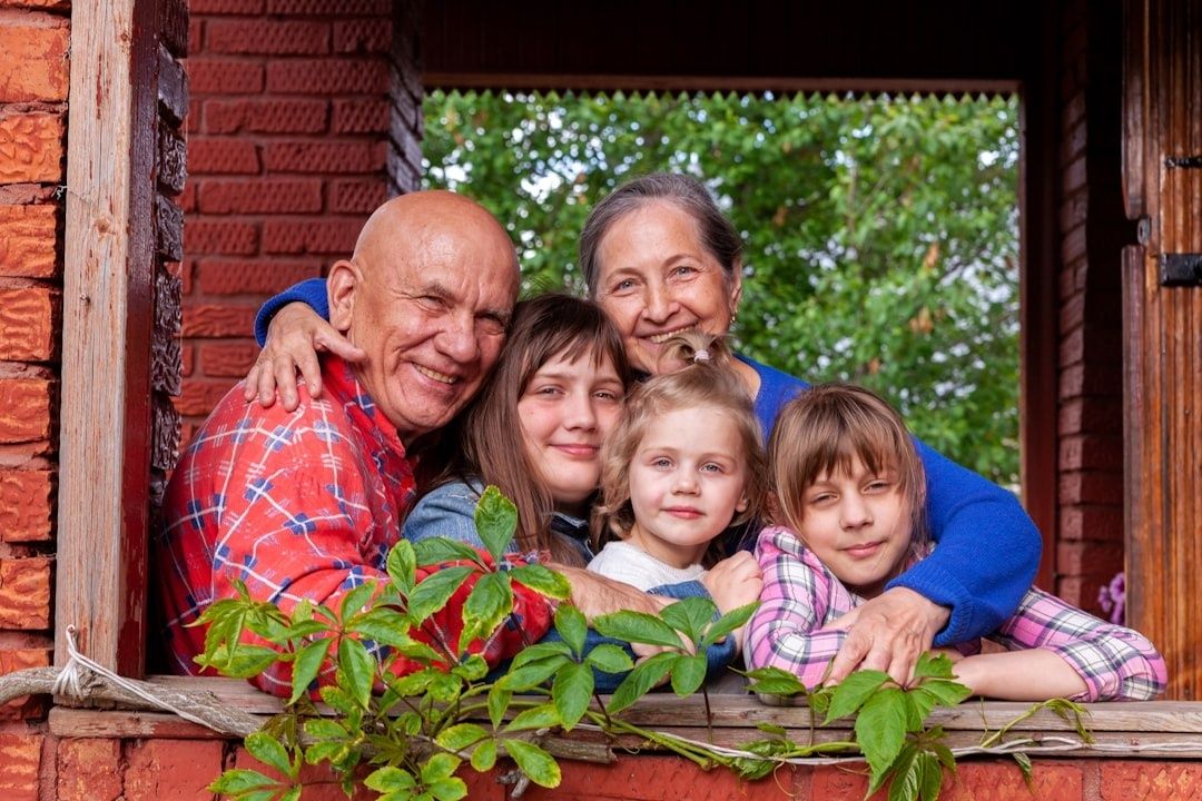 Drei Generationen lächeln gemeinsam an einem offenen Fenster